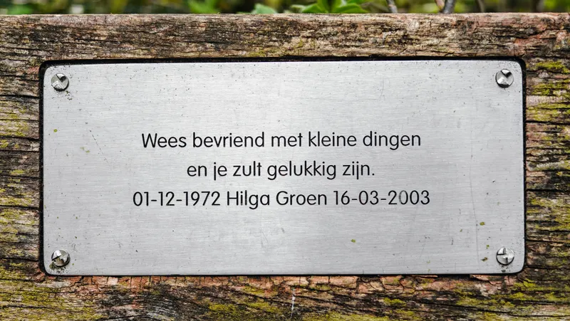 Bankje met de tekst 'Wees bevriend met kleine dingen en je zult gelukkig zijn'